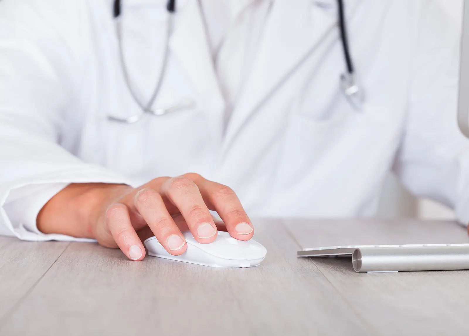 Close-up Of Male Doctor's Hand Using Computer for EHR
