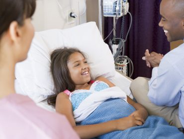 Doctor checking on child in hospital