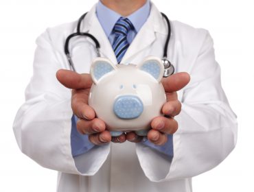 Doctor Holding Piggy bank