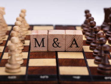 Chessboard With Wooden Blocks Showing Mergers And Acquisitions Concept