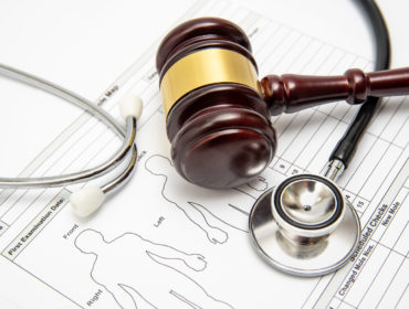 A Wooden Judge Gavel And Stethoscope On A Medical Chart. Medical