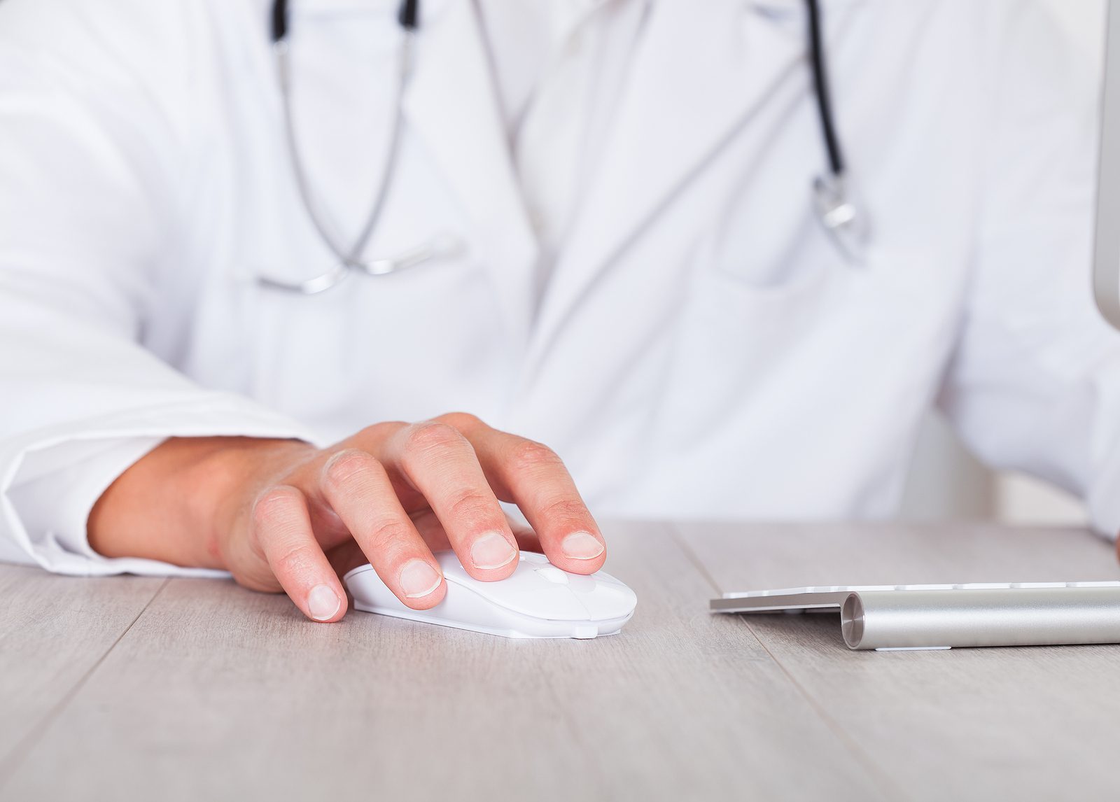 Close-up Of Male Doctor's Hand Using Computer for EHR