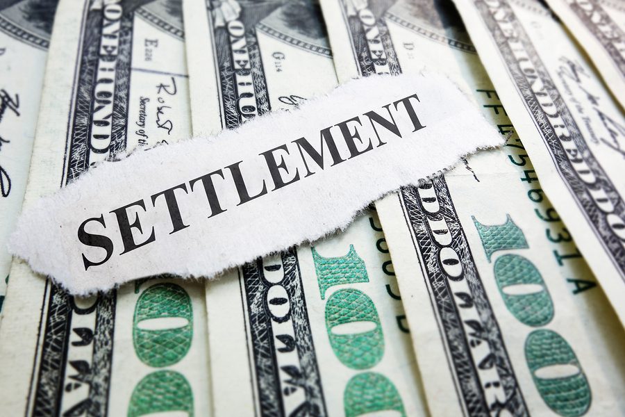 Piece of Paper that Says Settlement Resting On Money